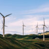 Many wind turbines standing in hilly pasture