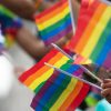 Gay pride, LGBTQ rainbow flags being waved in the air at a pride event