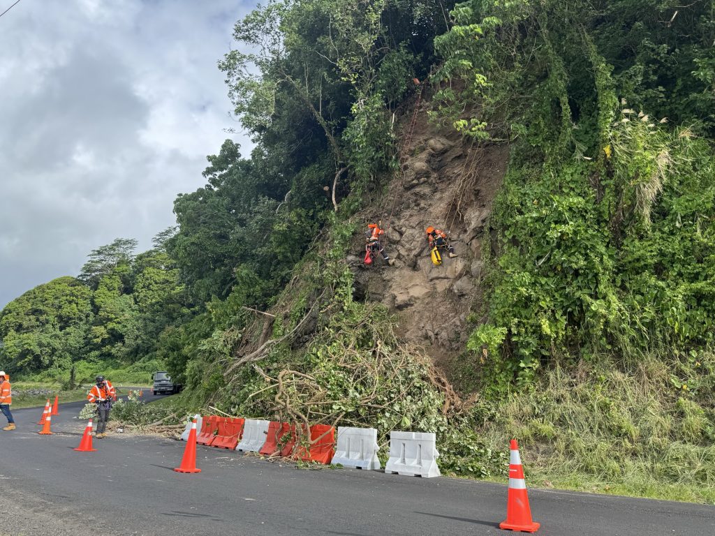 absailing contractors on the side of east coast road to strengthen samoas coastal road network with rock removal